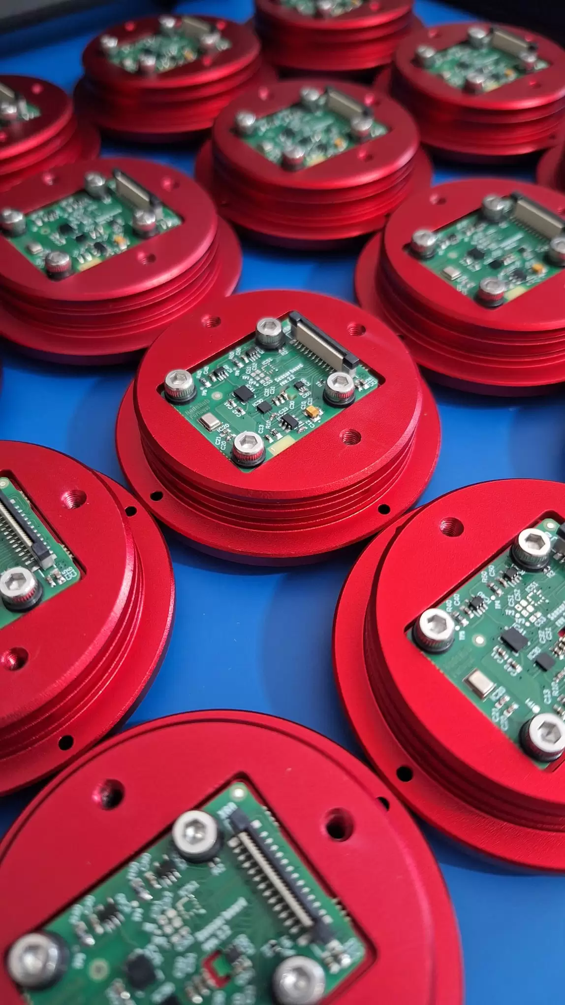 Vários sensores Edge da Nodehub com placas de circuito integradas em bases vermelhas.